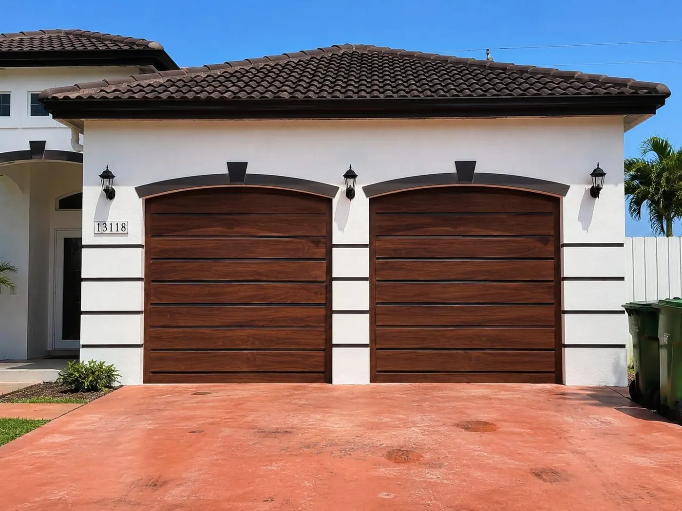 Design option: pair of arched dark wood-look garage doors on a Mediterranean-style home