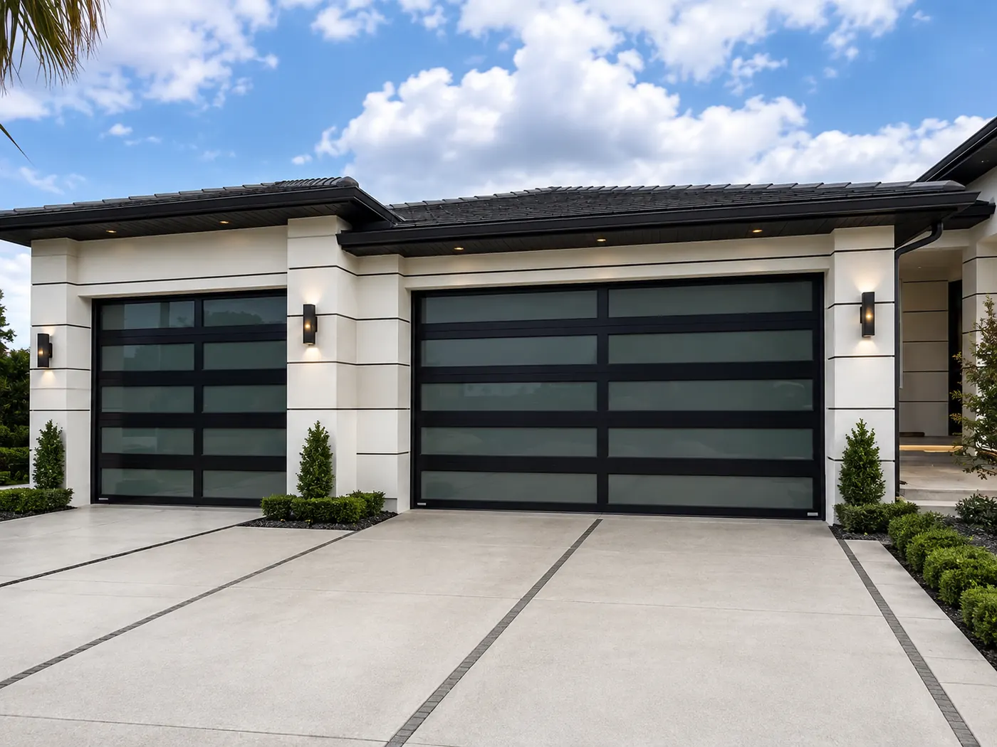 Two black-frame impact glass garage doors on a modern white single-story home in South Florida